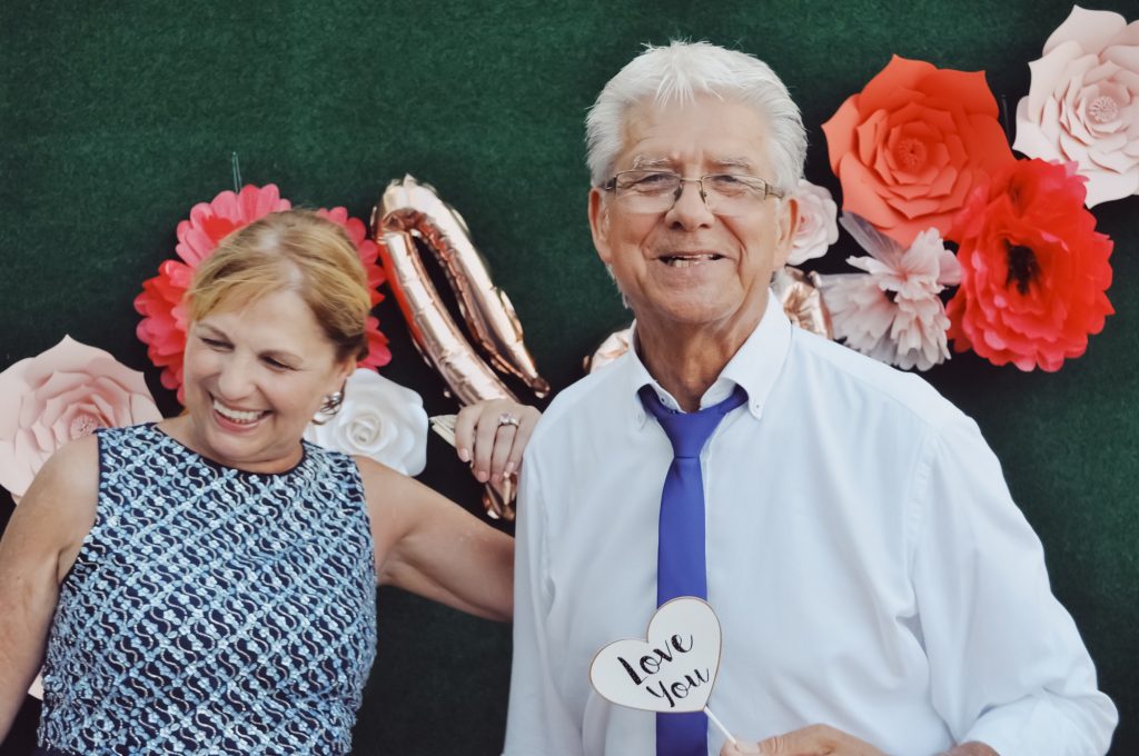 Elder couple enjoying photo booth in a party